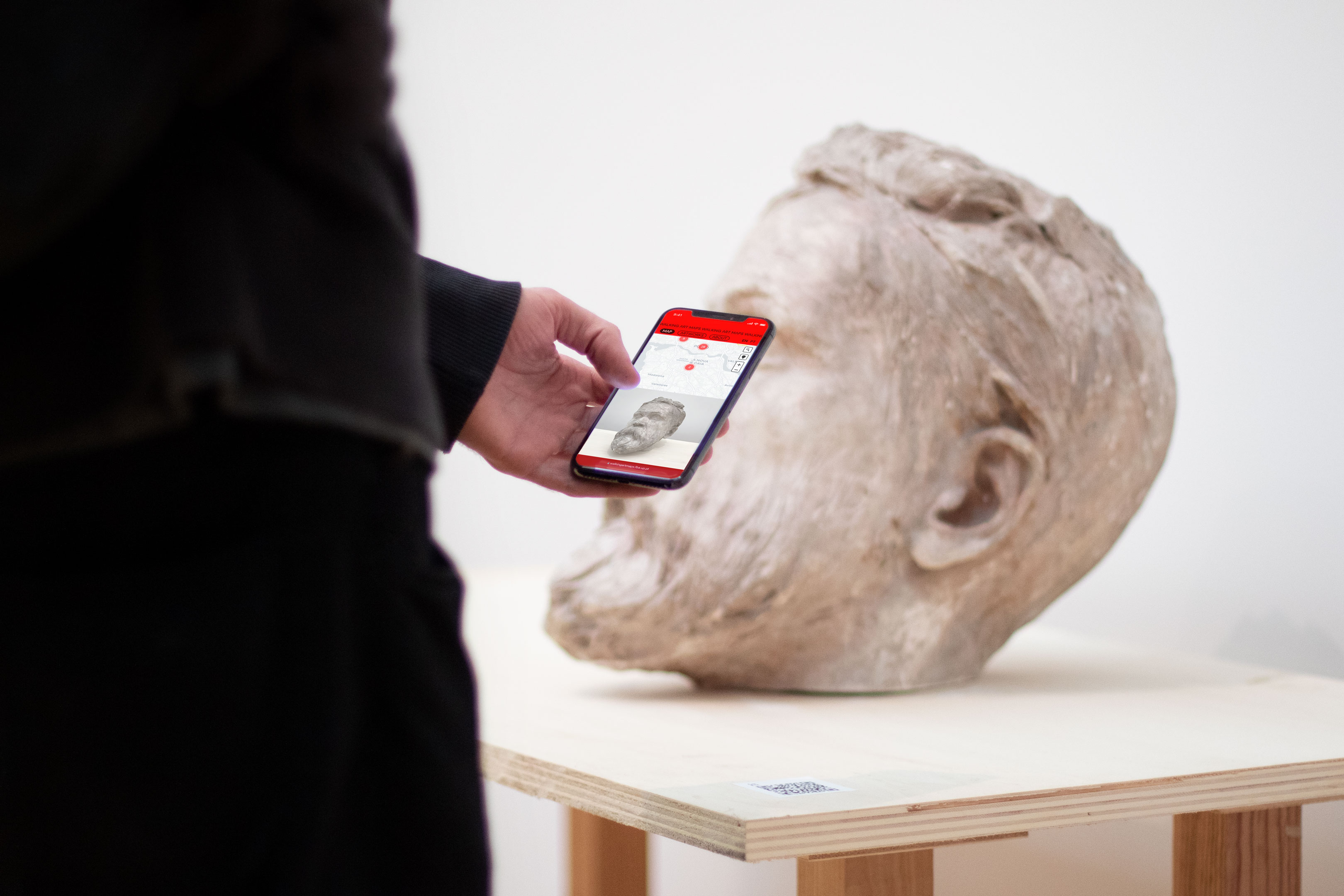 Person learning more about an artwork on their phone